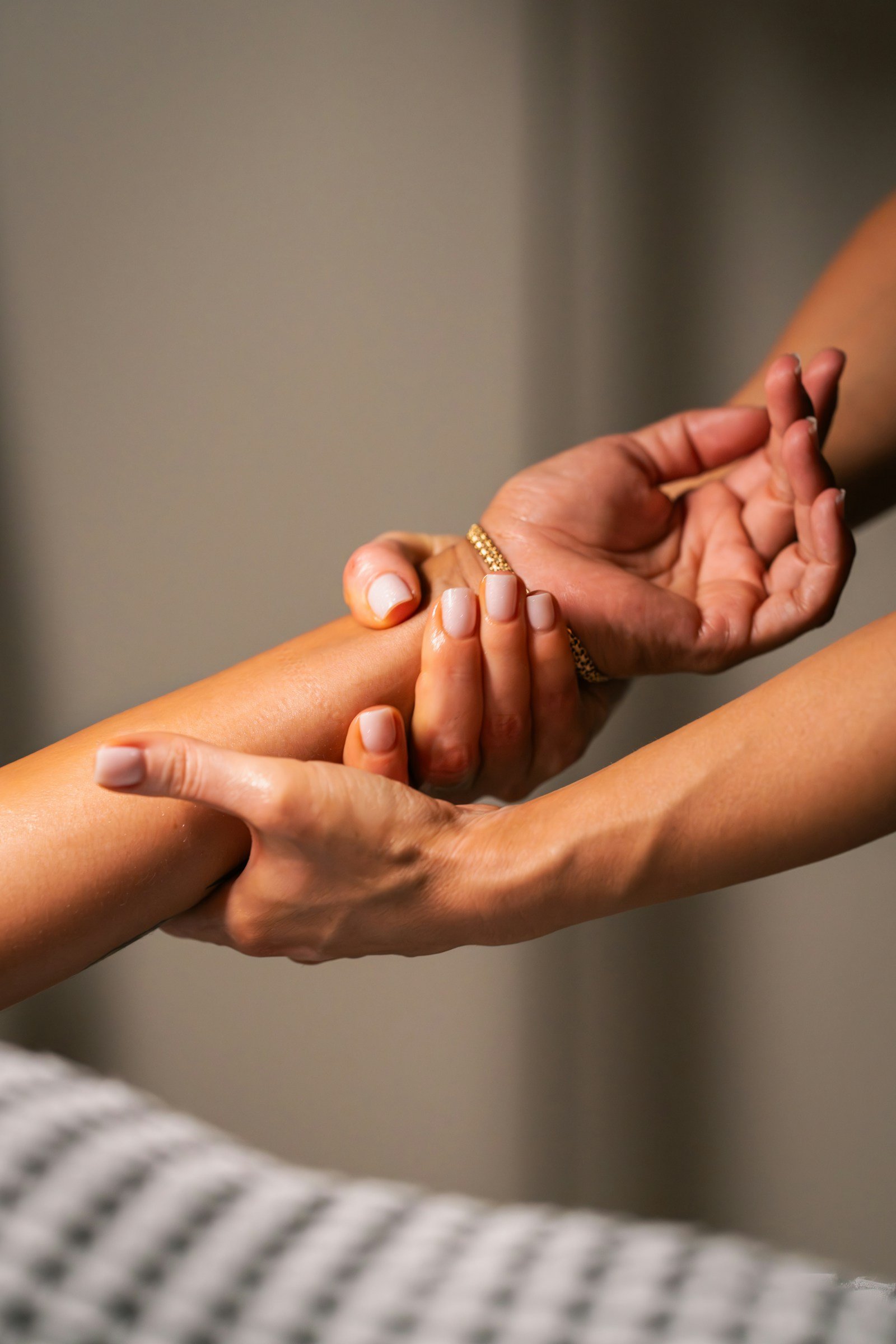 Hands applying gentle pressure along a forearm